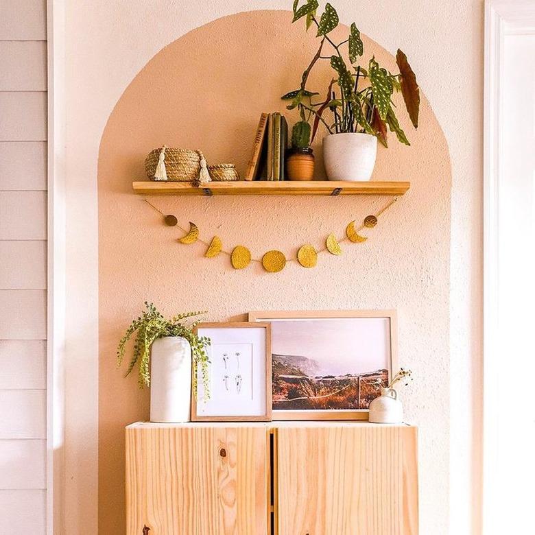 moon phase wall hanging above wood credenza