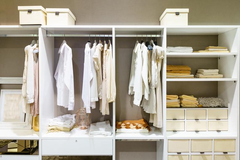 Clothes hanging on rail in walk-in closet.