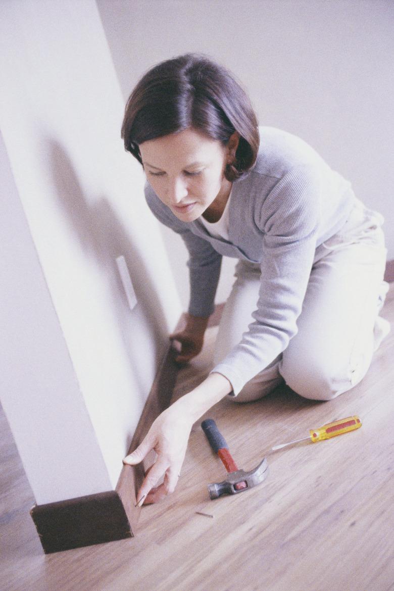 Woman Installing Baseboard