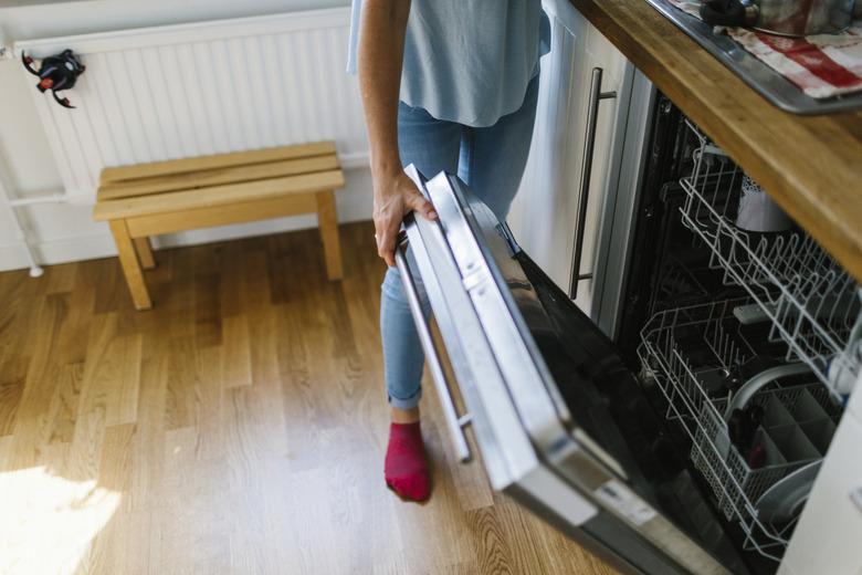 Woman opening dishwasher