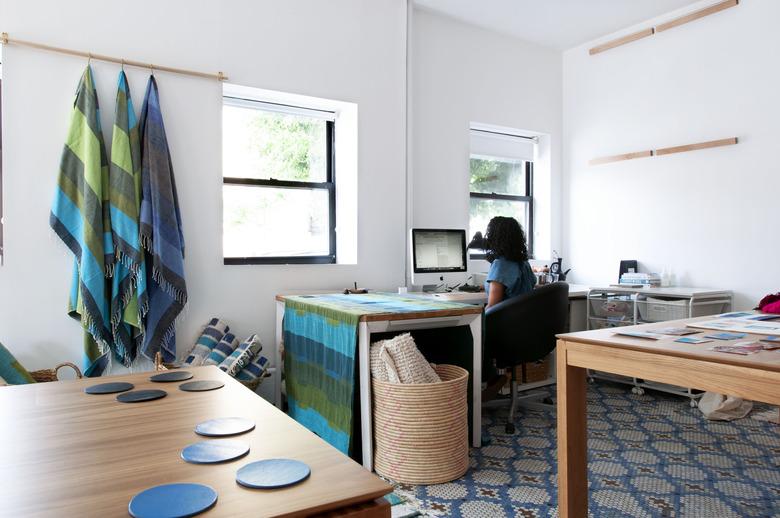 person sitting at desk space with wood tables nearby