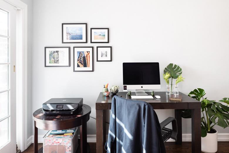 office space with computer and framed photos on the wall