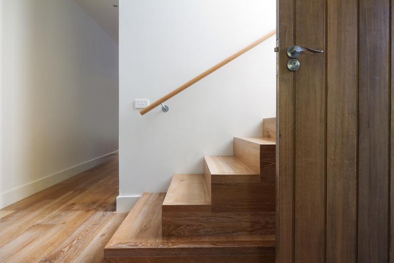 Modern staircase of oak wood beside front door horizontal