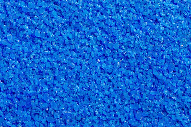 full frame background and texture of blue copper sulfate granules - close-up