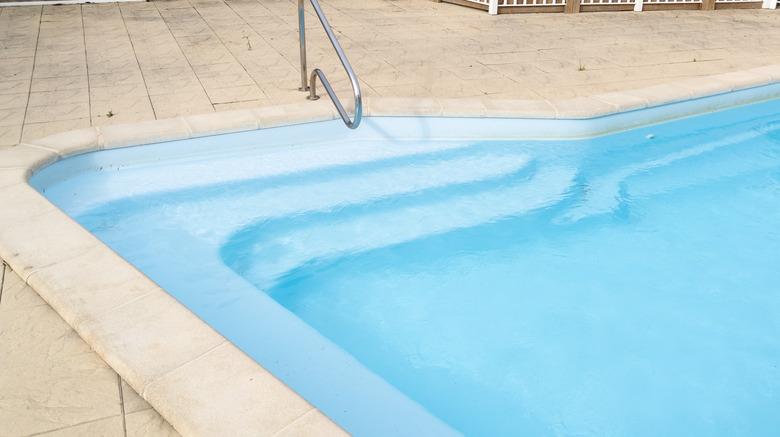 Detail stairs liner top view of swimming pool with blue water.