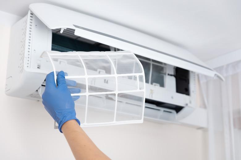 Technician cleaning air conditioner filter