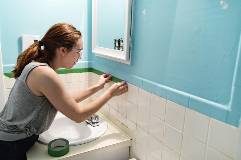 Young woman step by step DIY in home small bathroom.