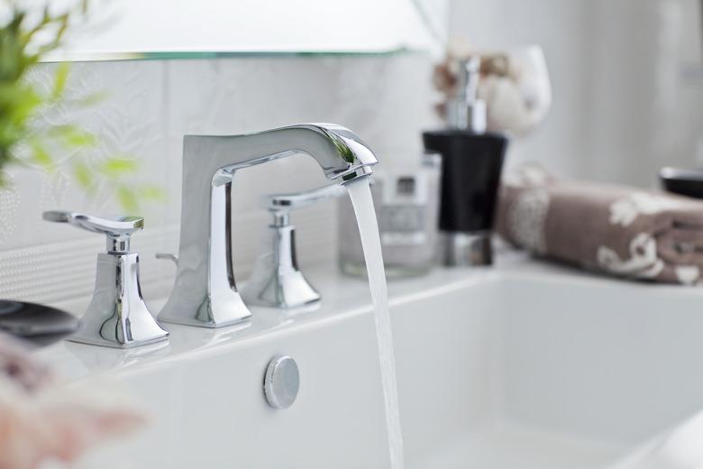 Water pouring out of modern bathroom faucet