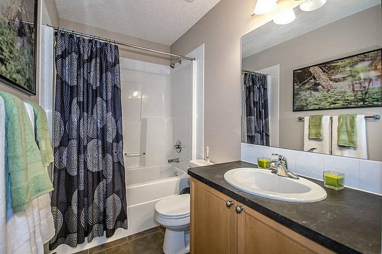 Shower curtain offsets otherwise bright bathroom.