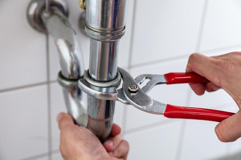 Plumber Repairing Sink With Adjustable Wrench