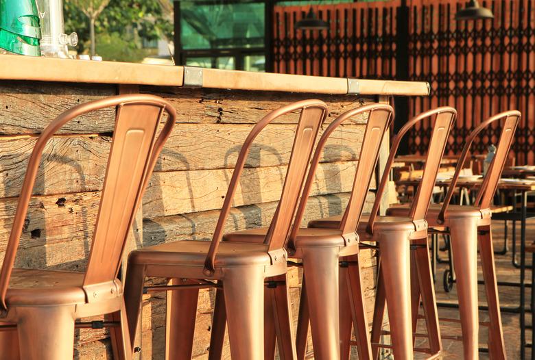 Lineup of painted metal bar stools.