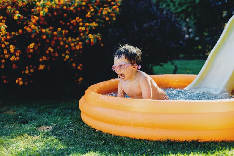 little boy having fun in inflatable pool