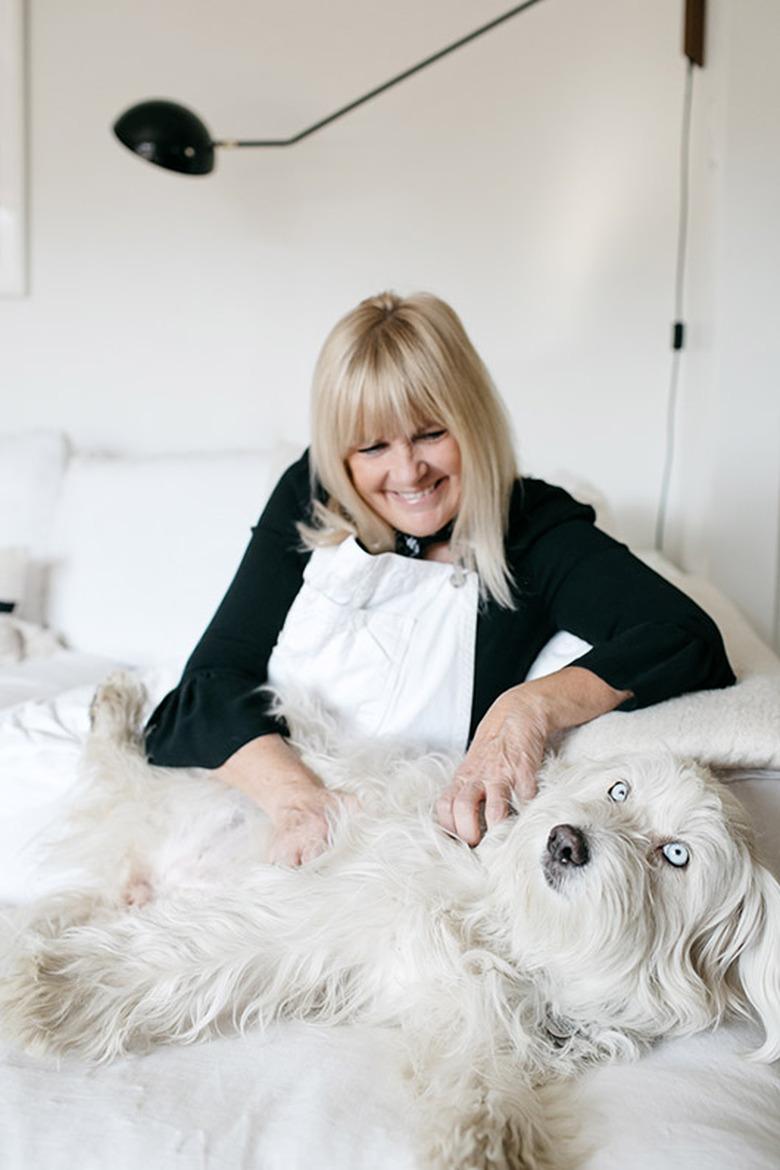 SF Girl by Bay Victoria Smith and dog in living room with Serge Mouille wall sconce