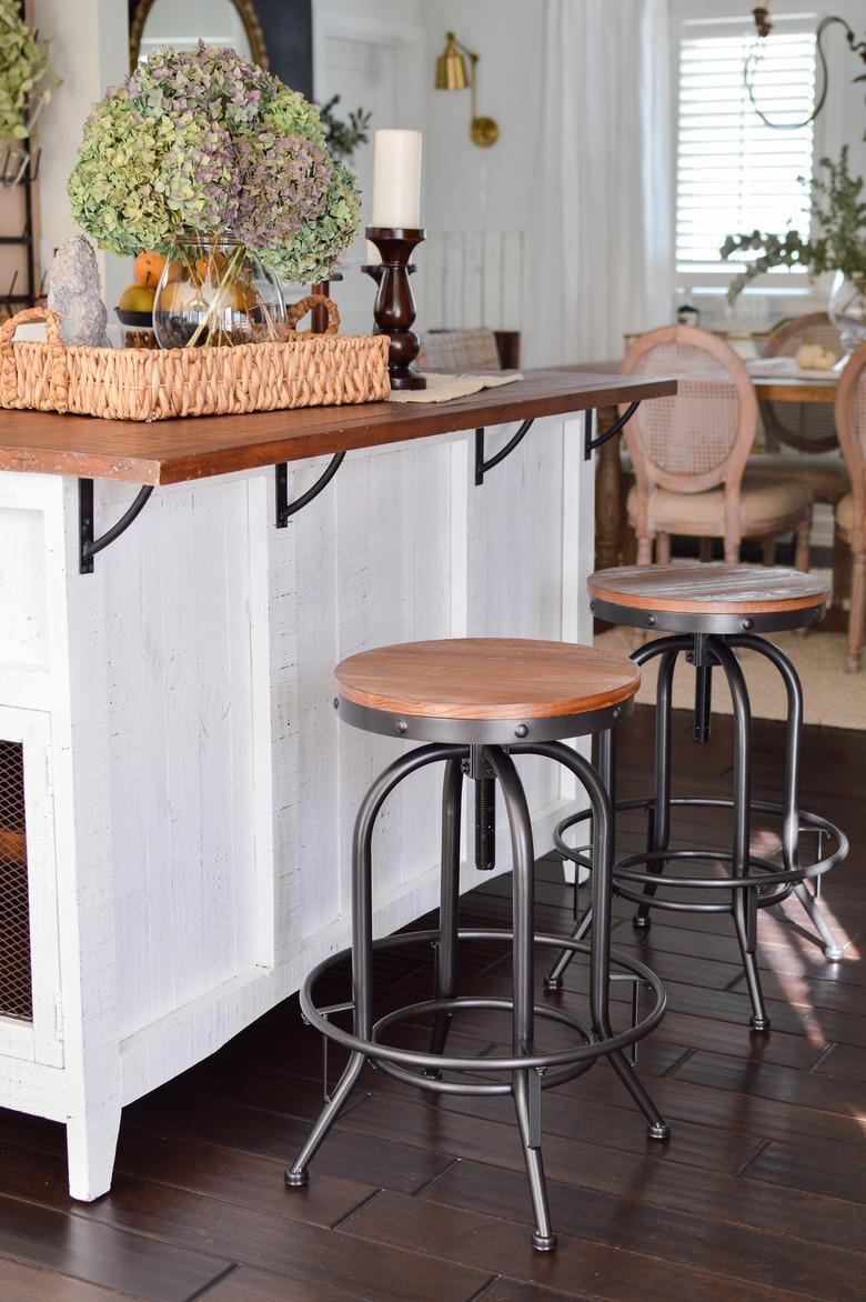 Industrial farmhouse kitchen with white island and metal bar stools