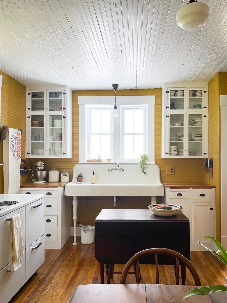 yellow and white industrial farmhouse kitchen with large sink