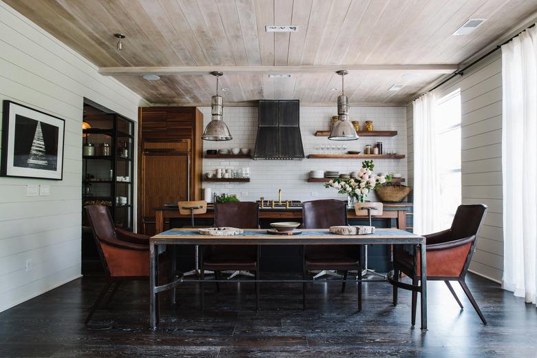 modern farmhouse cabinetry in room with reclaimed wood industrial kitchen island and rustic dining table