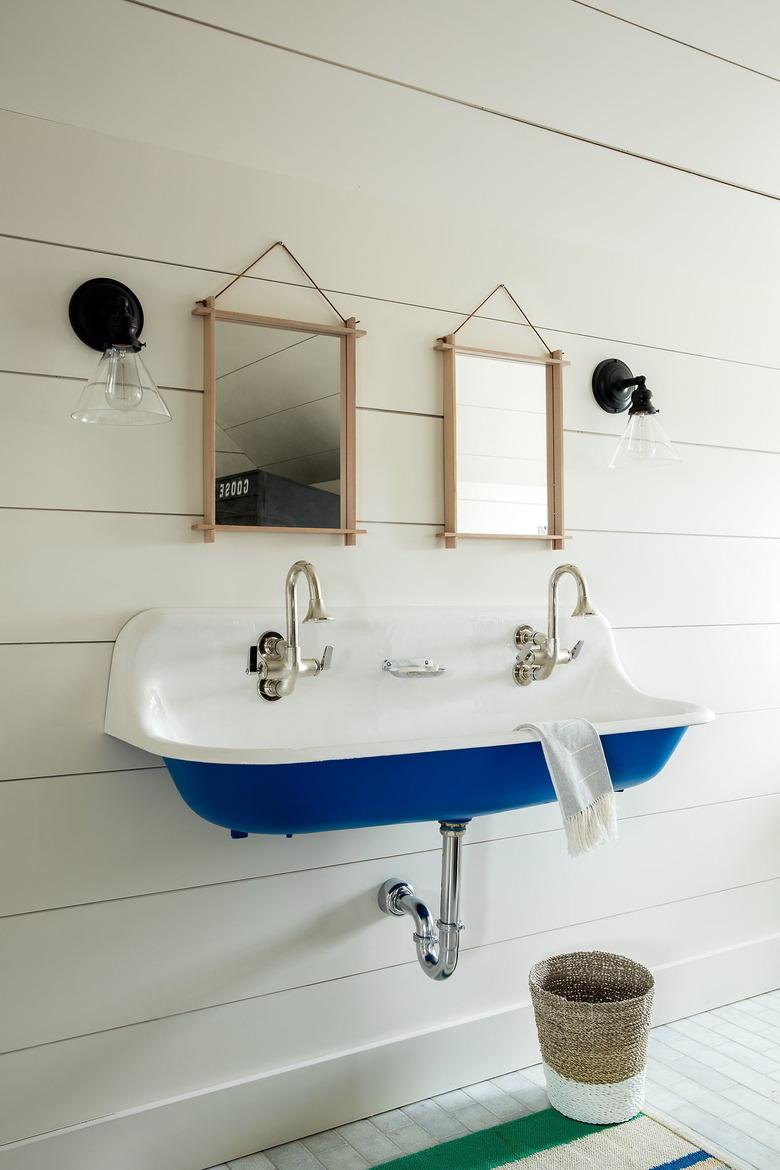 white bathroom trend with blue trough sink and gooseneck faucets