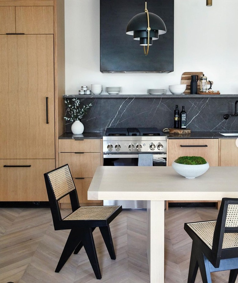 pale wood kitchen with black soapstone backsplash and chevron floors