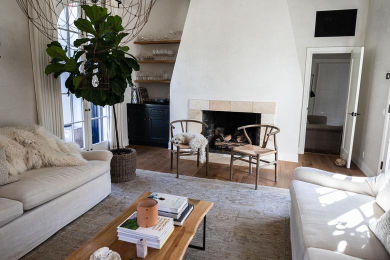 ivory colored living room with fireplace and fiddle leaf fig tree