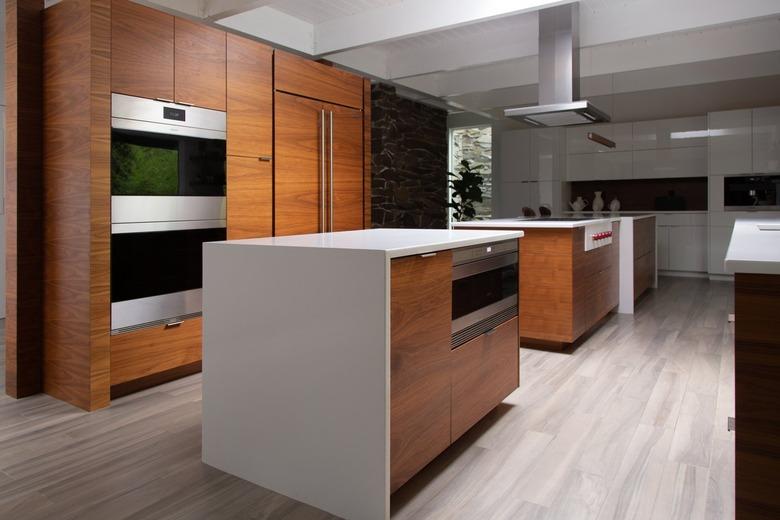 Minimalist contemporary kitchen with wood cabinets and white counters, and gray hardwood floors.