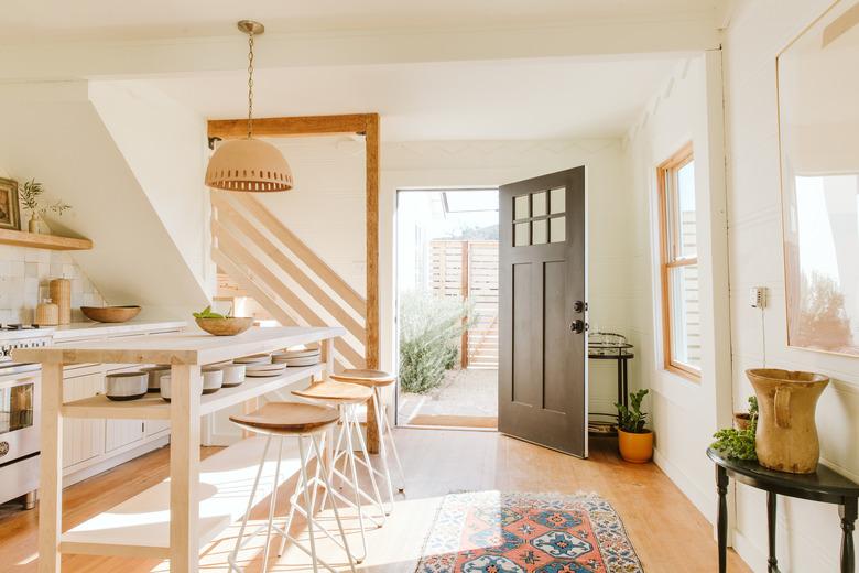 modern bohemian kitchen island decor with ceramics, wood bowl, and pendant light