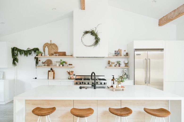 kitchen island decor on wooden footed tray in minimalist kitchen with green wreath