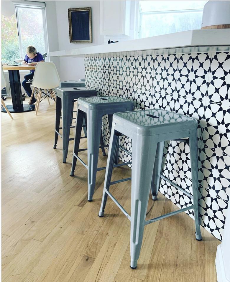 black and white tile on kitchen island table with blue barstools