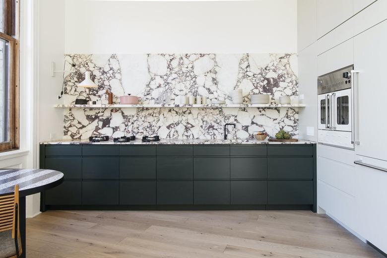 marble kitchen backsplash with dark green cabinets