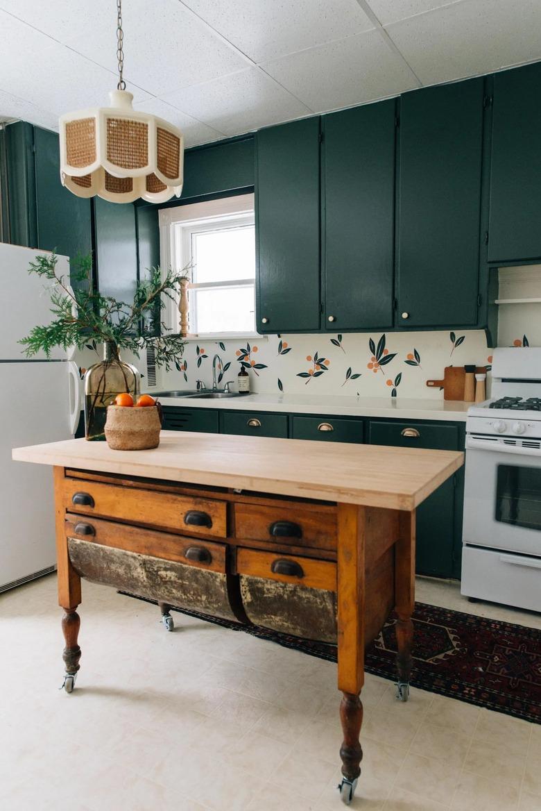 vintage style kitchen cart in kitchen with teal cabinets