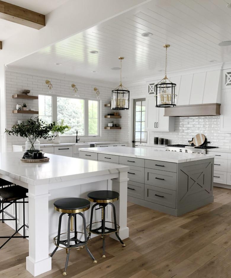 large white kitchen with gray island and marble island