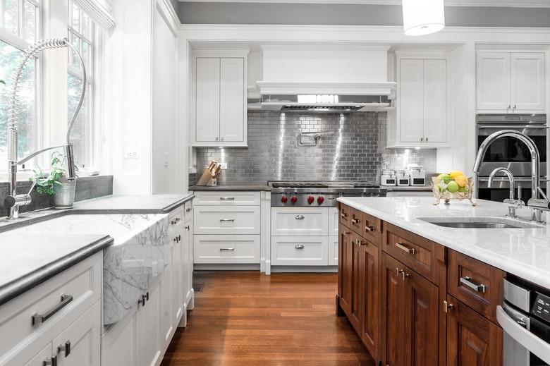 white kitchen with dark wood cabinets and metal subway tile backsplash