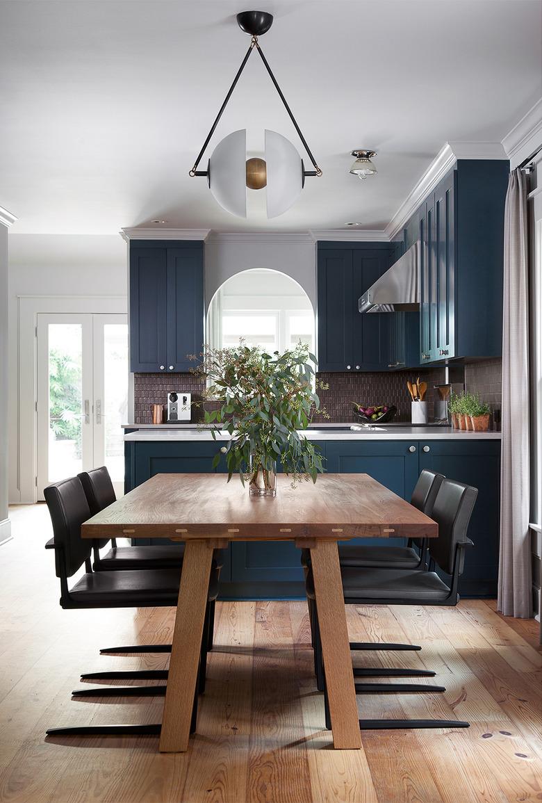 dark blue kitchen cabinets with bronze mosaic tile backsplash