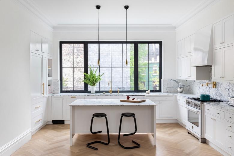 Paonazzo marble kitchen island in kitchen with wood floors and black counter stoold