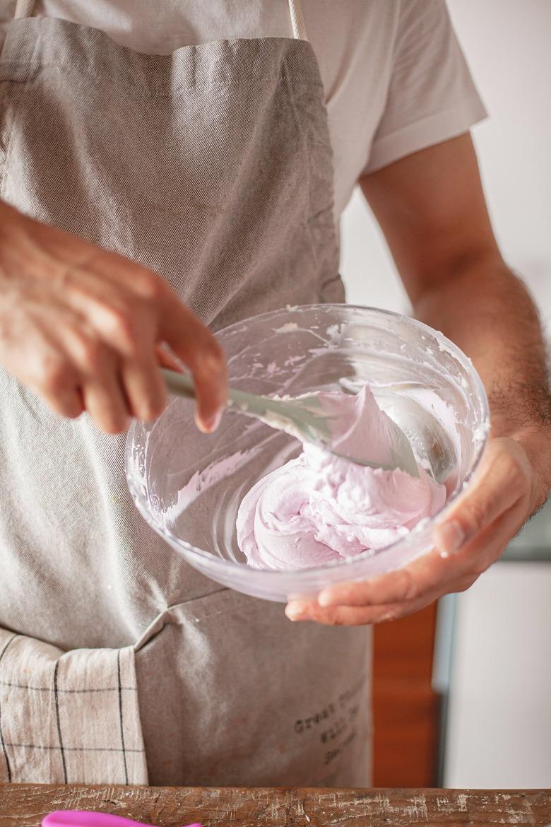 Person mixing frosting in a bowl