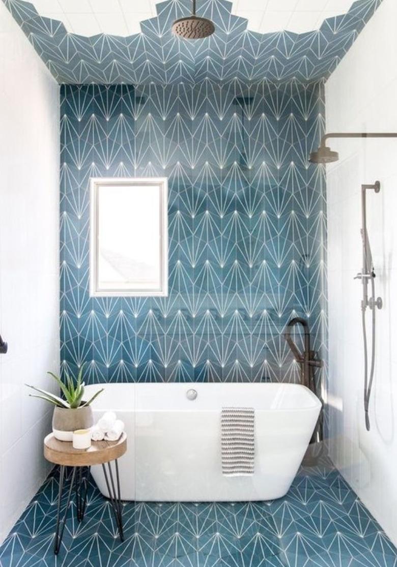 Shower and tub combo in this bathroom designed by Andrea West Design, with blue concrete tile on the floor and wall.