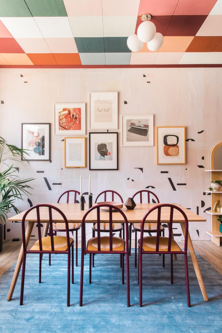 dining room with patterened wall paper and colorful ceiling tiles