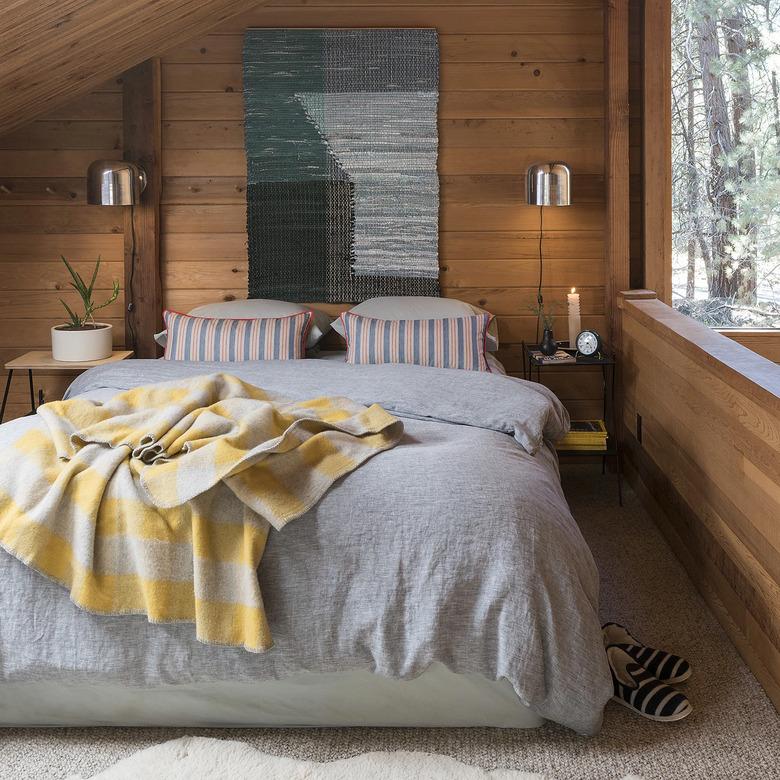 midcentury bedroom lighting idea with wall sconces on either side of bed