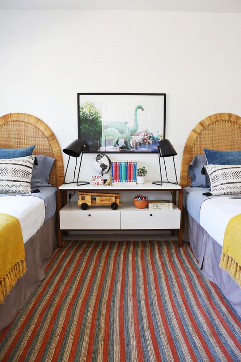 Midcentury kids' bedroom idea with matching twin beds, cane headboards, and modern table lamps