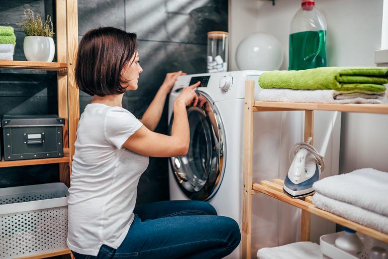 Woman choosing program on washing machine