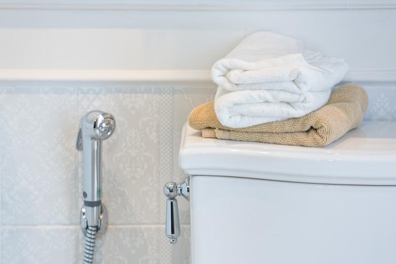 Towels on top of a toilet tank