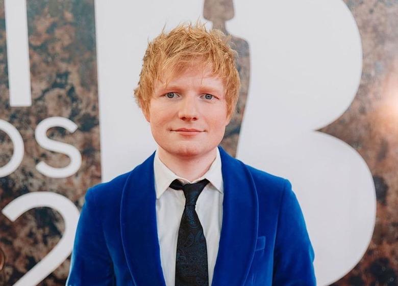 Ed Sheeran in a royal blue suit with a black tie.