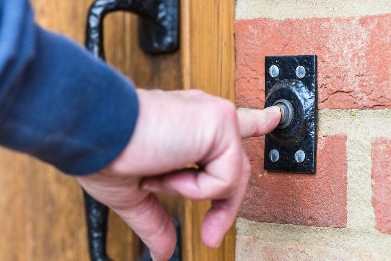 Pressing a doorbell button.