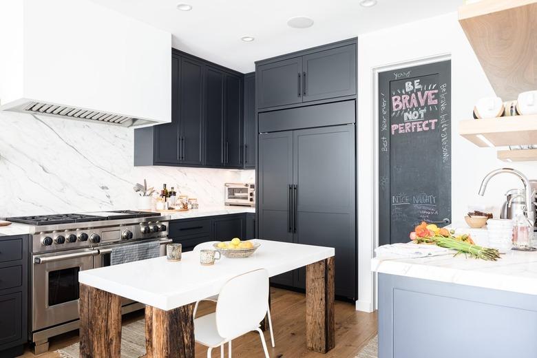 White walled kitchen with gray cabinets and wood floor