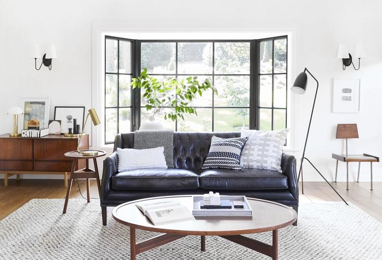 midcentury modern family room design by Emily Henderson with leather couch and credenza.