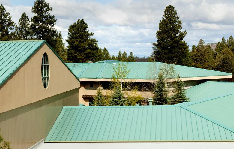 A green steel roof amongst trees