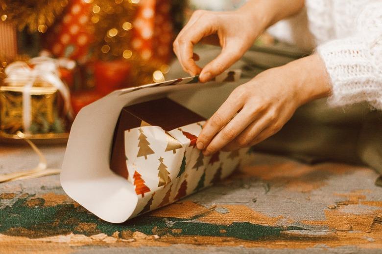 Hands wrapping a box with wrapping paper