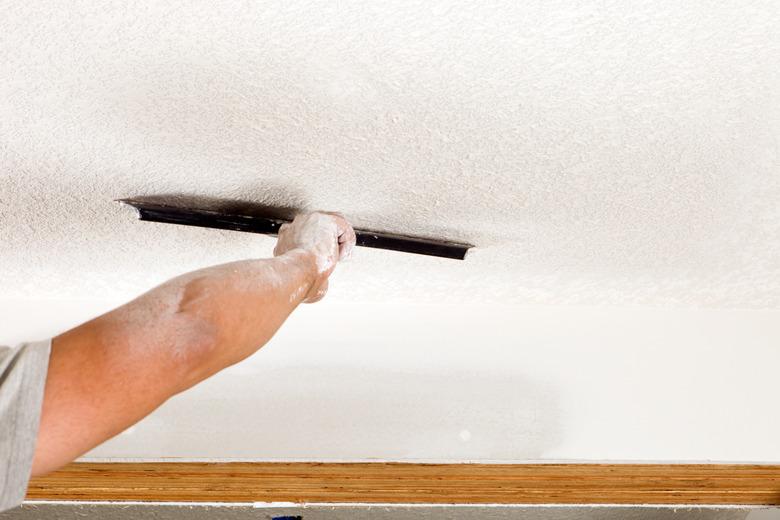 Worker Troweling Drywall Mud on a Ceiling for Knockdown Texture