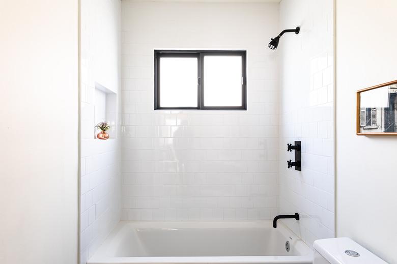 bathroom with shower/tub combo and black accents