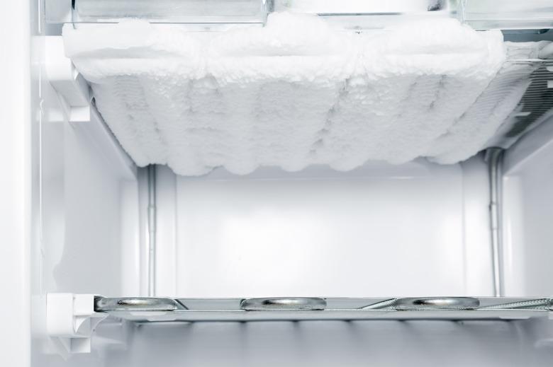 Frozen ice in the empty freezer. Problem and solution concept.