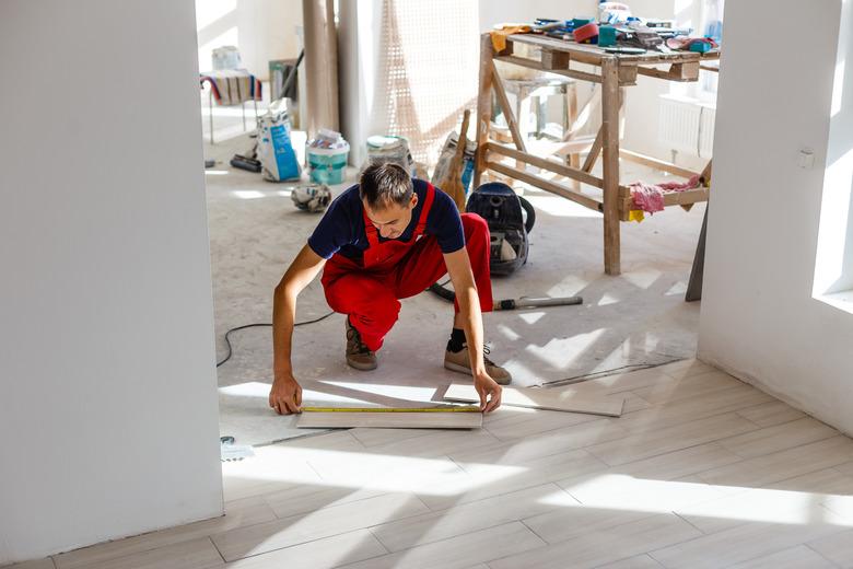 Installing ceramic floor tiles - measuring and cutting the pieces, closeup